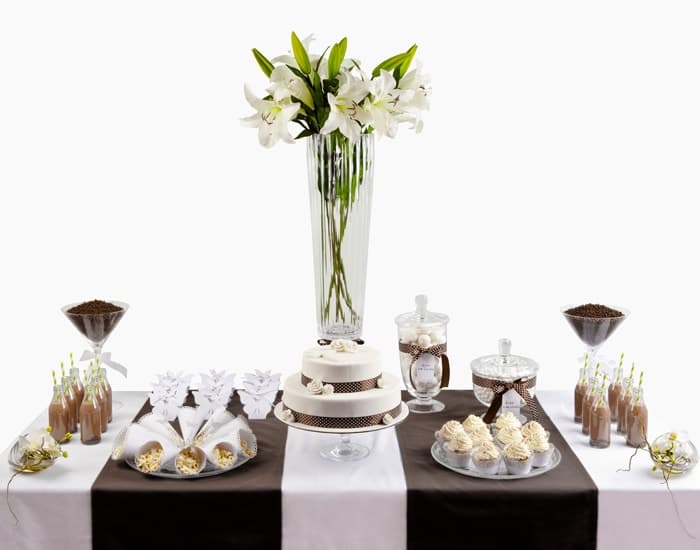Mesa dulce en blanco y chocolate con tarta, cupcakes y batidos