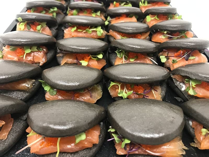 Mini baos negros de salmón ahumado con huevas y brotes