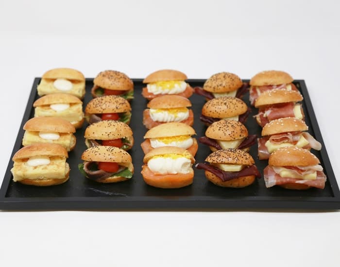 Bandeja de mini bocadillos surtidos con tortilla, salmón y jamón